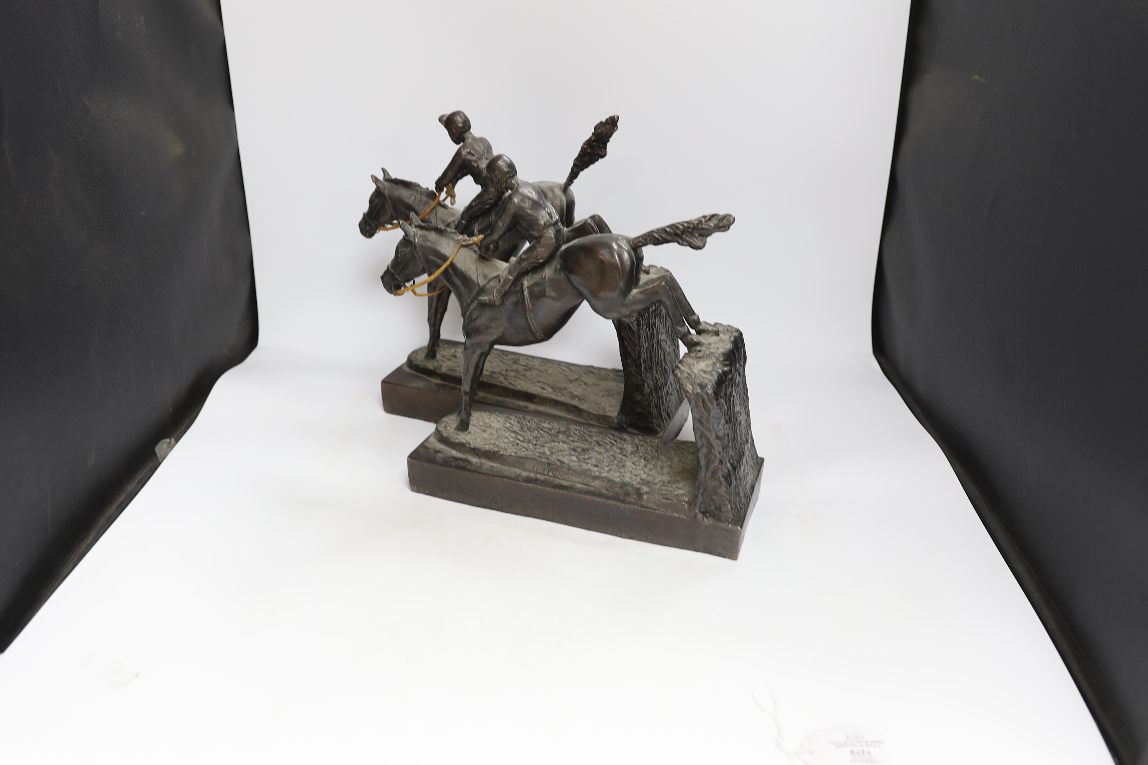 A pair of bronzed resin models of steeplechasers, 31cm